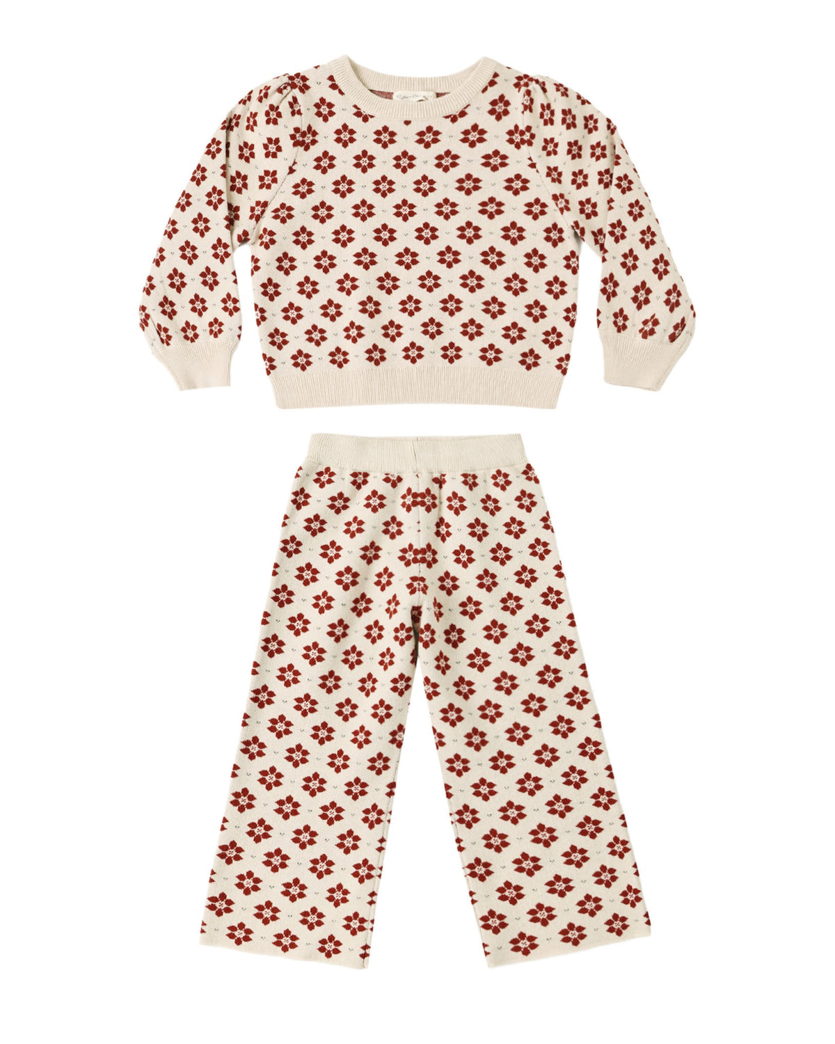A two-piece knit loungewear set for kids, featuring a cropped long-sleeve top and matching pants in cream with a repeating red floral pattern, displayed on a solid white background.