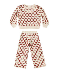 A two-piece knit loungewear set for kids, featuring a cropped long-sleeve top and matching pants in cream with a repeating red floral pattern, displayed on a solid white background.