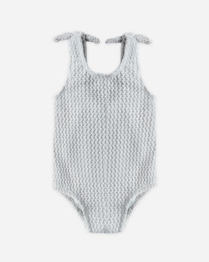Textured swimsuit with bow straps on a white background