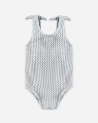 Textured swimsuit with bow straps on a white background