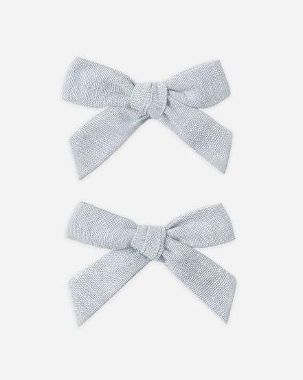 Two light gray hair bows on a white background