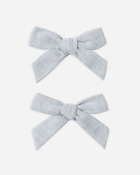Two light gray hair bows on a white background