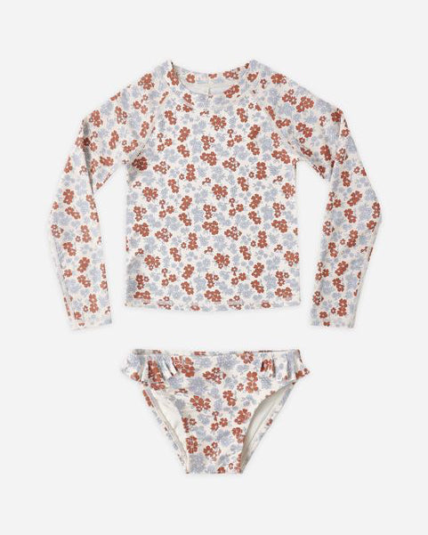 Floral patterned long-sleeve rash guard and bikini bottom set on a white background