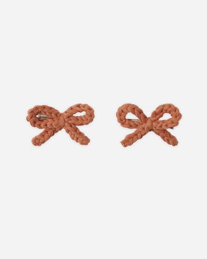Pair of brown bow-shaped earrings on a white background