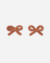 Pair of brown bow-shaped earrings on a white background