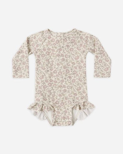 Floral patterned baby onesie with ruffles on a white background