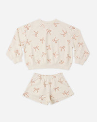Children's outfit with top and shorts featuring bow pattern on a white background