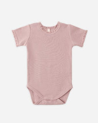 Pink baby bodysuit with ruffled collar on a white background