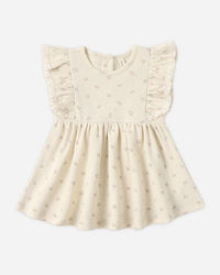 Beige baby dress with ruffled details on a white background