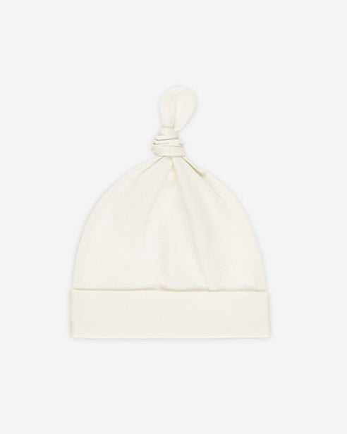 White baby hat on a light beige background