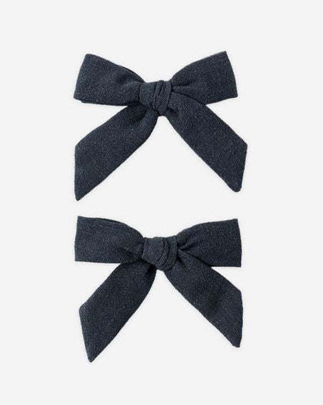 Two dark blue hair bows on a white background