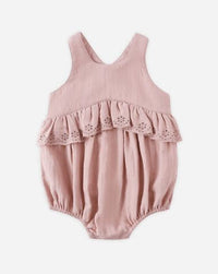Pink baby romper with lace details on a white background