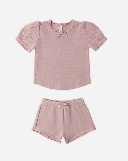 Pink children's top and shorts set on a white background