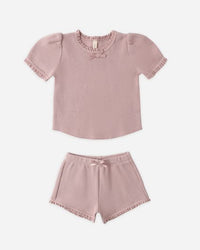 Pink children's top and shorts set on a white background