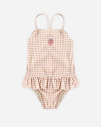 Pink gingham baby romper with ruffle details on a white background