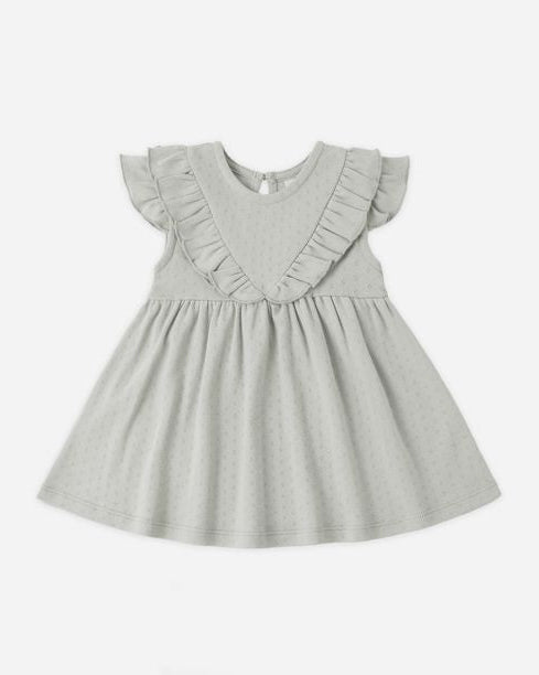 Light gray dress with ruffled details on a white background