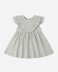 Light gray dress with ruffled details on a white background