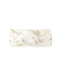 White headband with gold polka dots on a white background