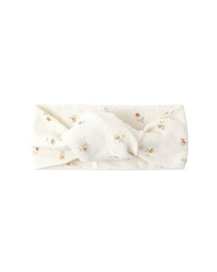White headband with gold polka dots on a white background