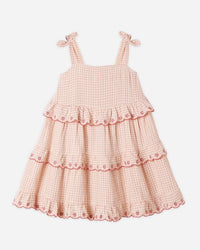 Pink checkered dress with ruffled layers on a white background