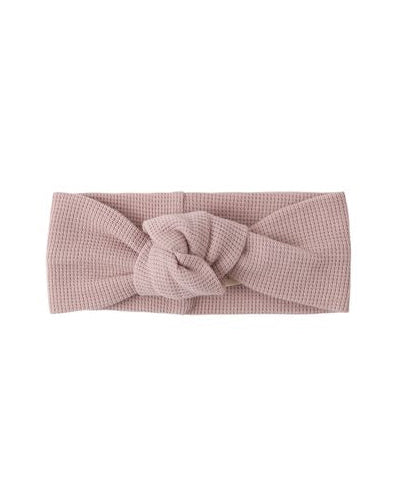 Pink knotted headband on a white background