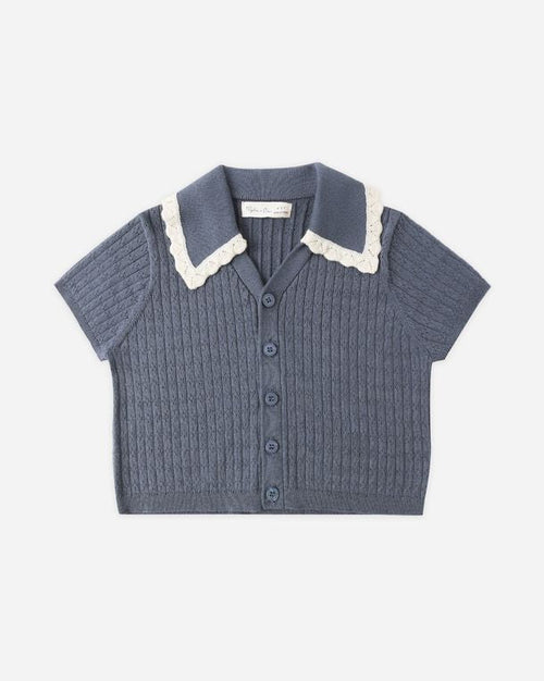 Blue knitted shirt with white collar on a light gray background