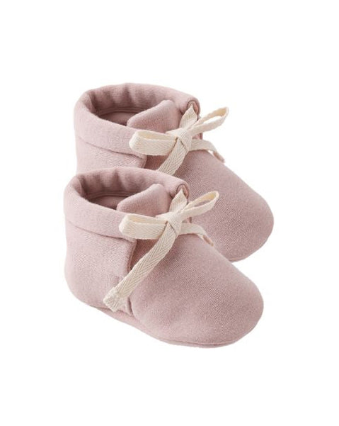 Pair of pink baby booties with white laces on a white background