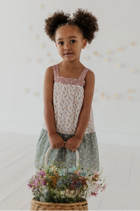 Young girl holding a basket of flowers against a white background