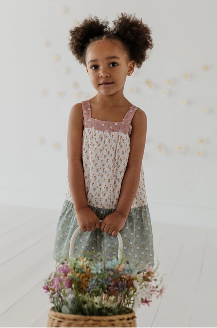 Young girl holding a basket of flowers against a white background