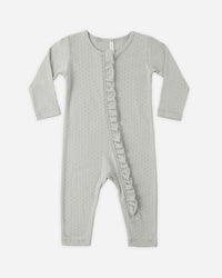 Gray baby onesie with ruffle details on a white background