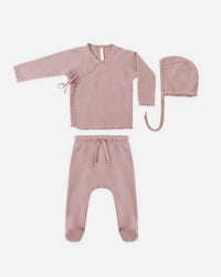 Pink baby outfit with top, pants, and hat on a white background