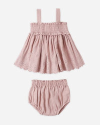 Pink baby dress with matching bloomers on a white background