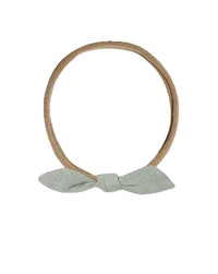 Two hairbands with bows, one beige and one brown, on a white background.