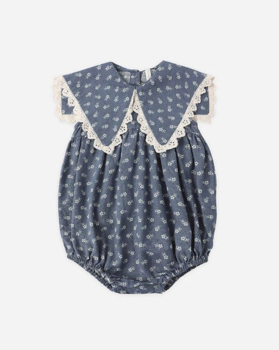 Blue baby romper with white floral pattern on a white background