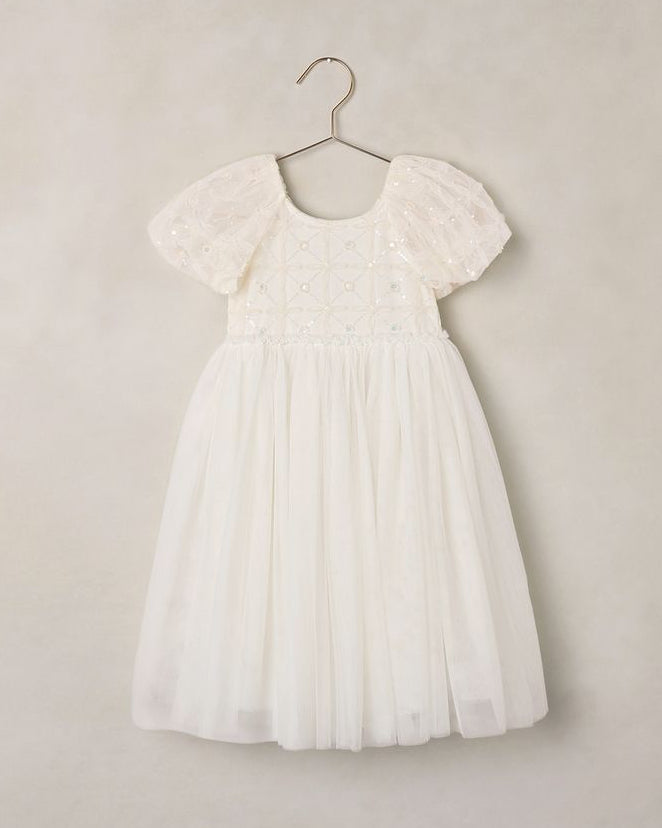 White lace dress on a hanger against a plain background