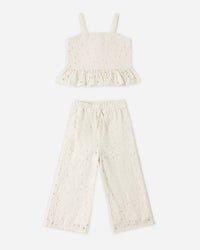 White lace top and pants set on a white background